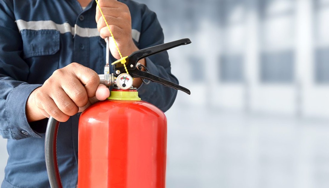 Man inspecting a fire extinguisher 