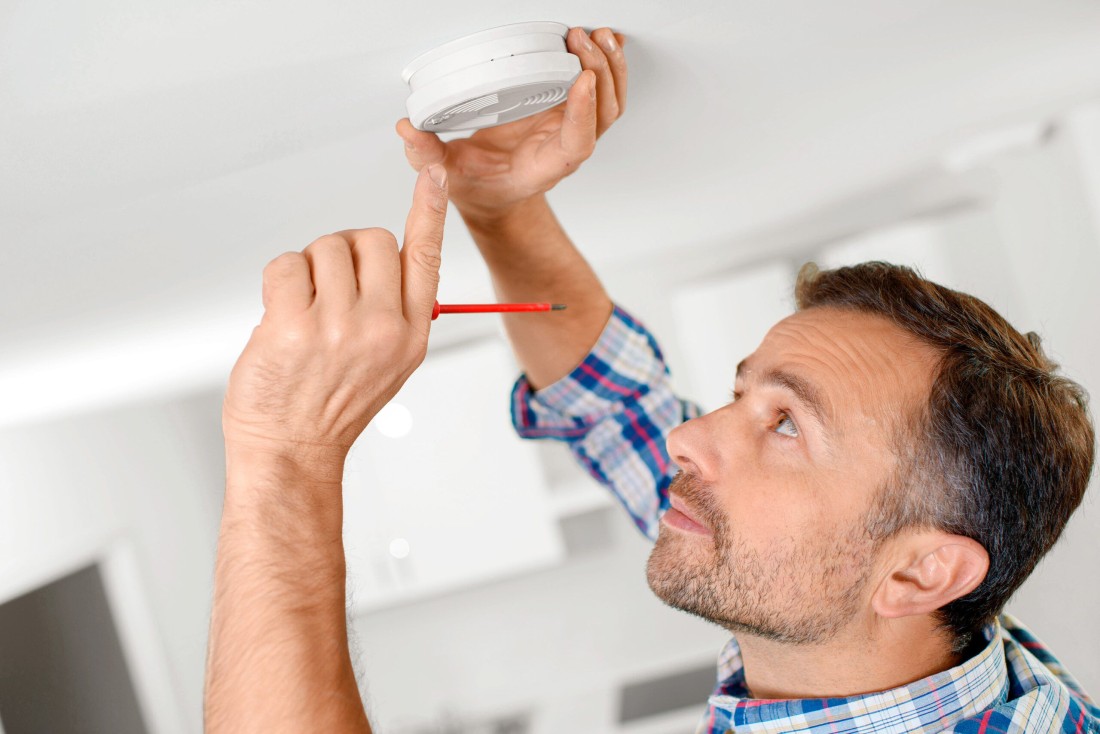 Man inspecting his fire alarm